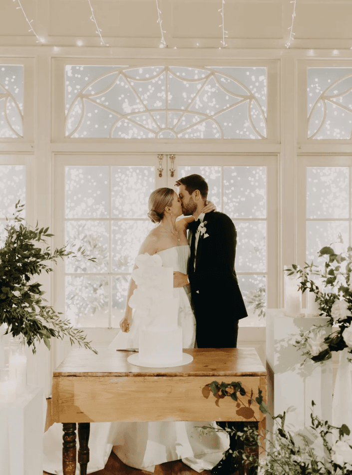 Couple kiss in front of fairy lights and fireworks