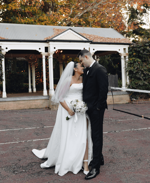 Couple pose on tennis court