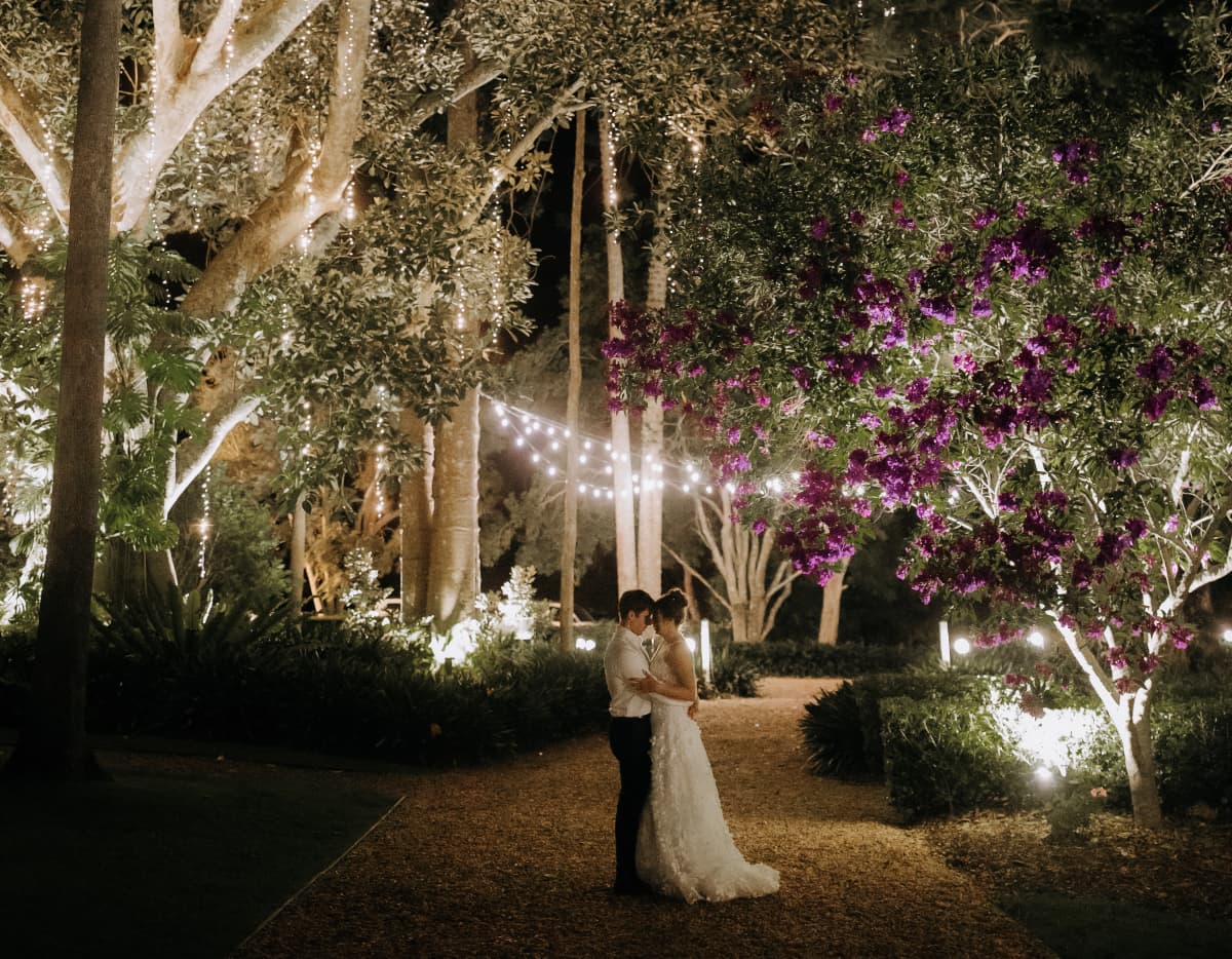 Couple embrace under fairy lights