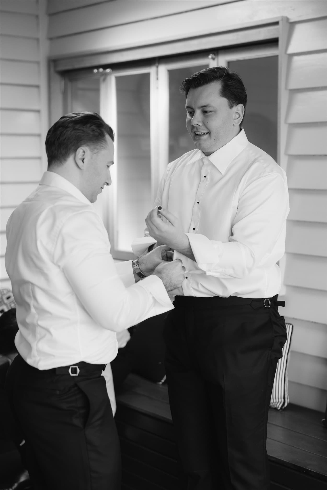 Groom buttonning up shirt