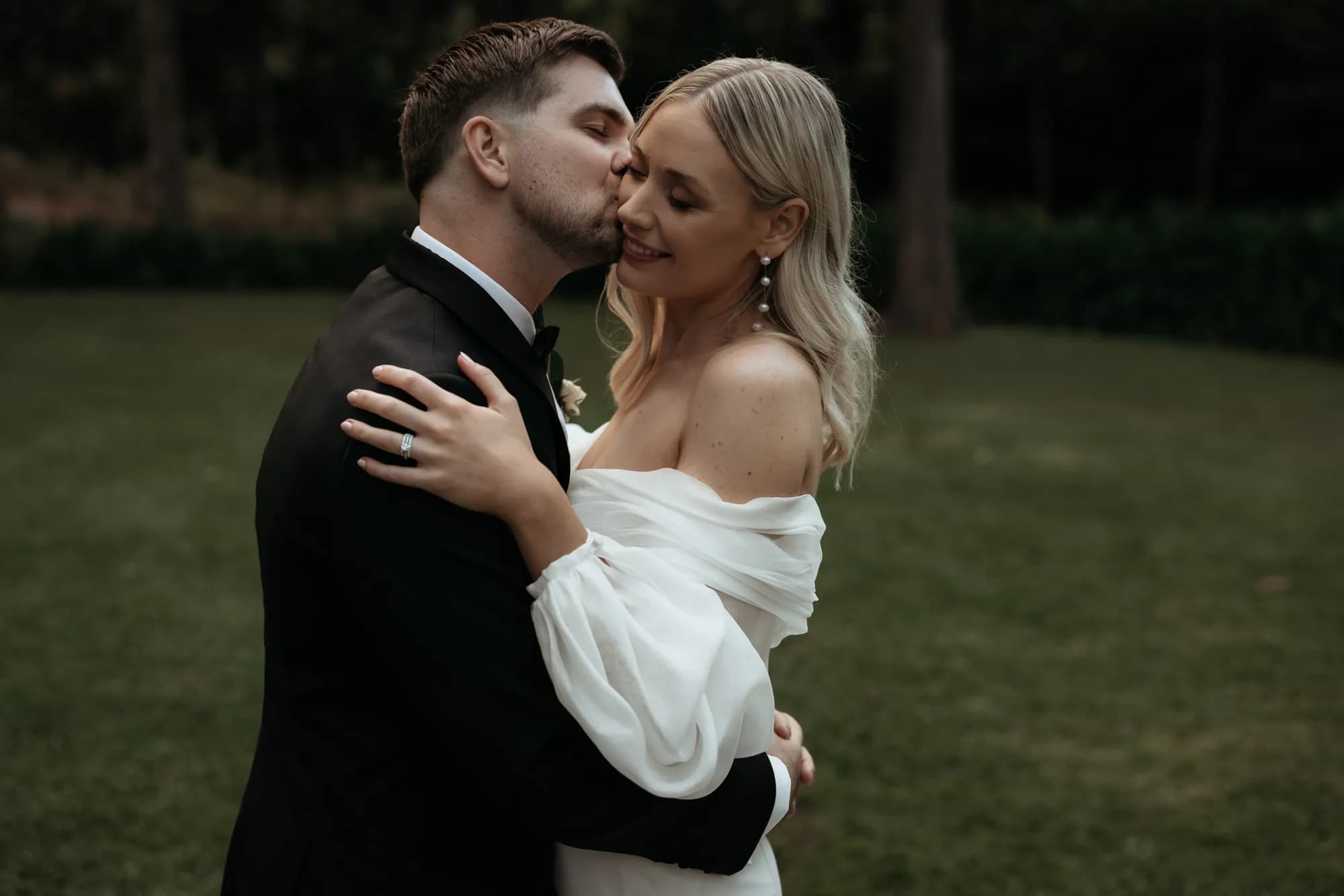 Couple embrace and kiss on their wedding day