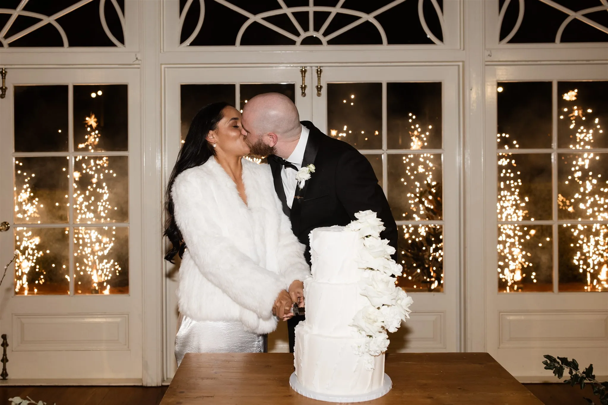 Bride and groom cutting cakes and kissing