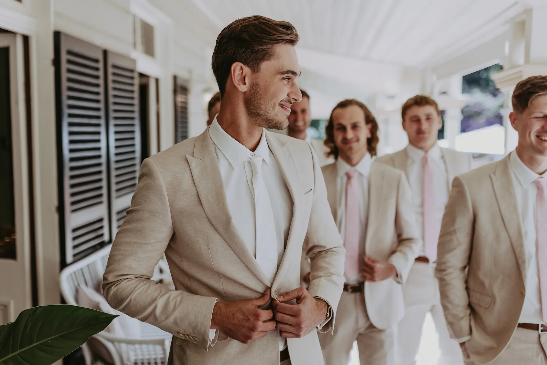 groom doing buttons of jacket up