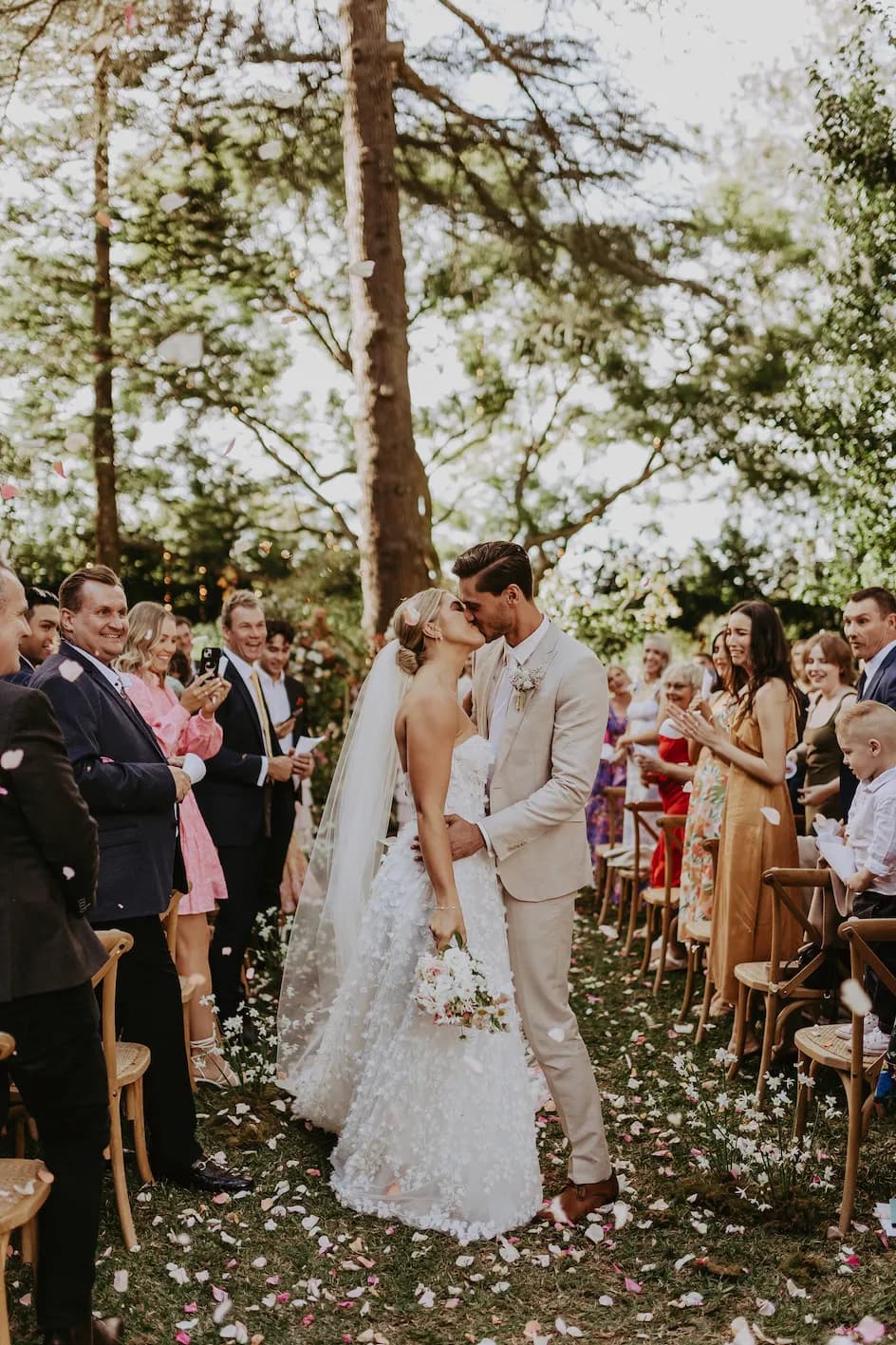 Bride and groom kissing in wedding aisle