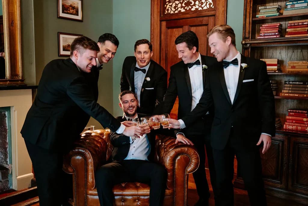 Groom and groomsman drinking whisky