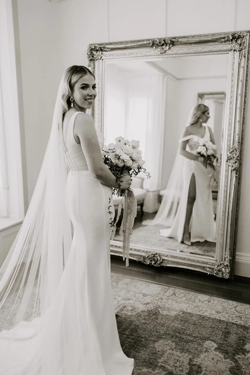 Bride looking into large mirror