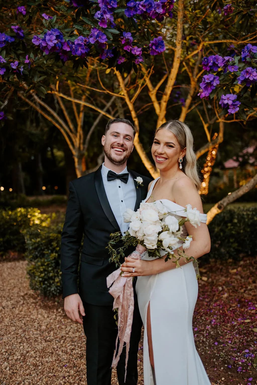 Bride and groom standing under tree