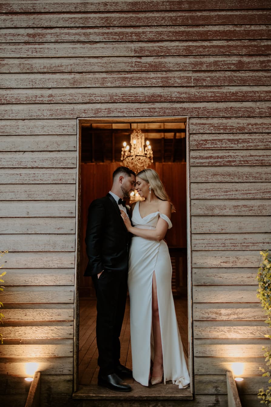 Bride and groom embracing in doorway