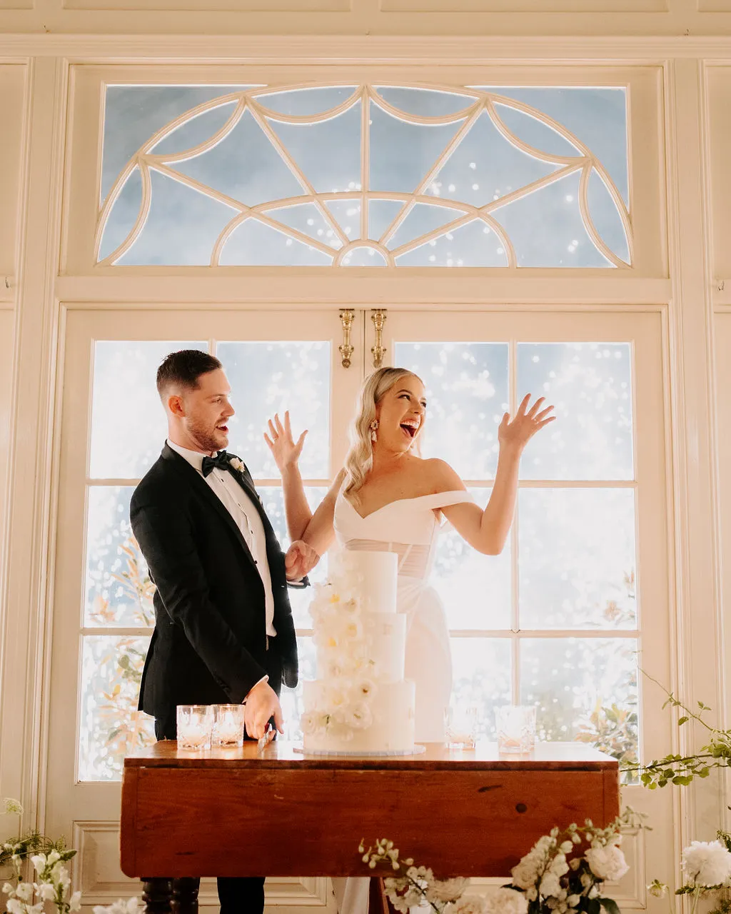 Bride and groom cutting cake in front of fireworks