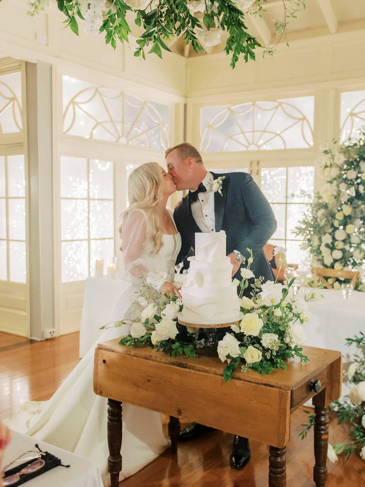 Bride and groom cutting the cake and kissing