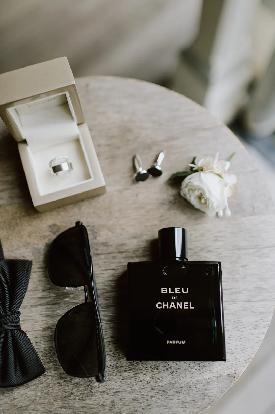 Groom cologne, sunglasses, flowers and ring