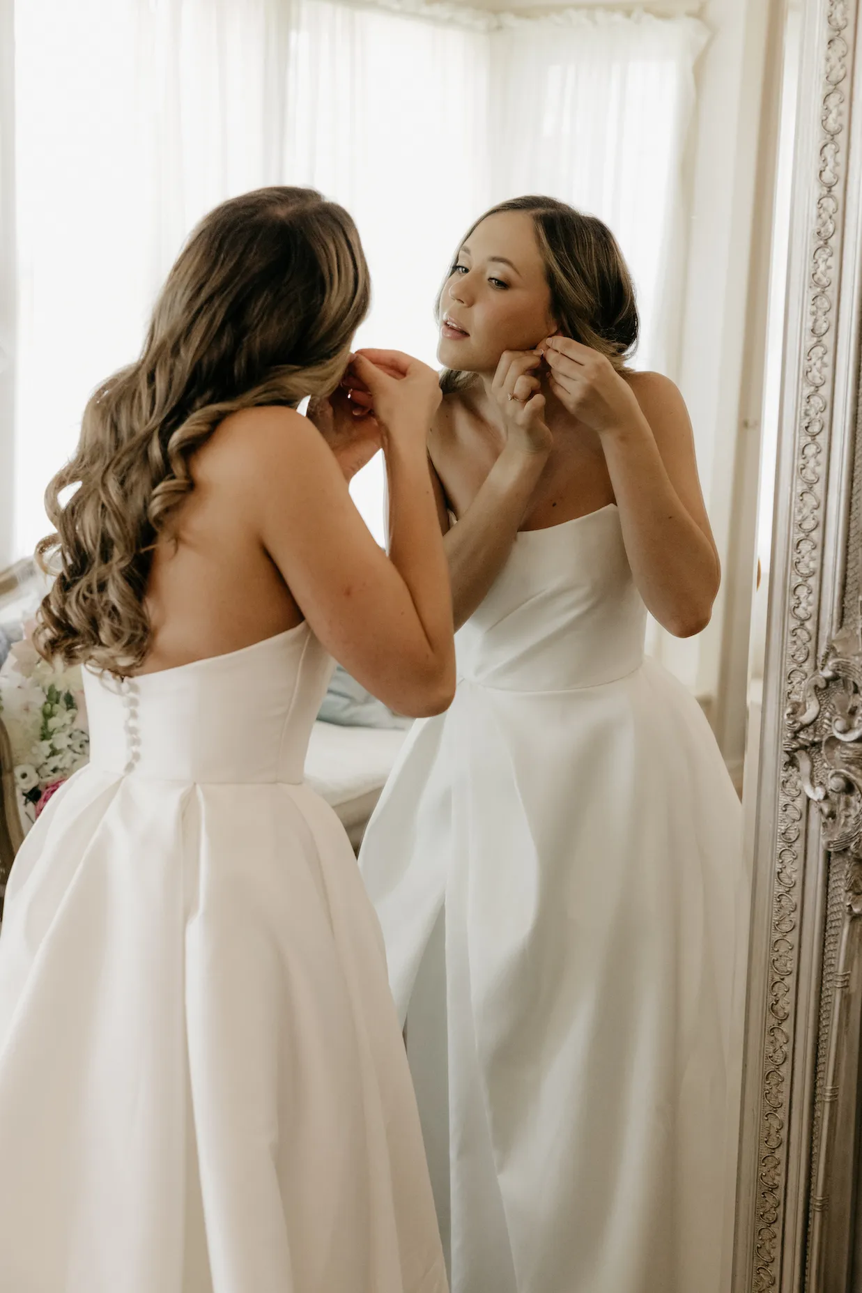 Bride putting in earrings