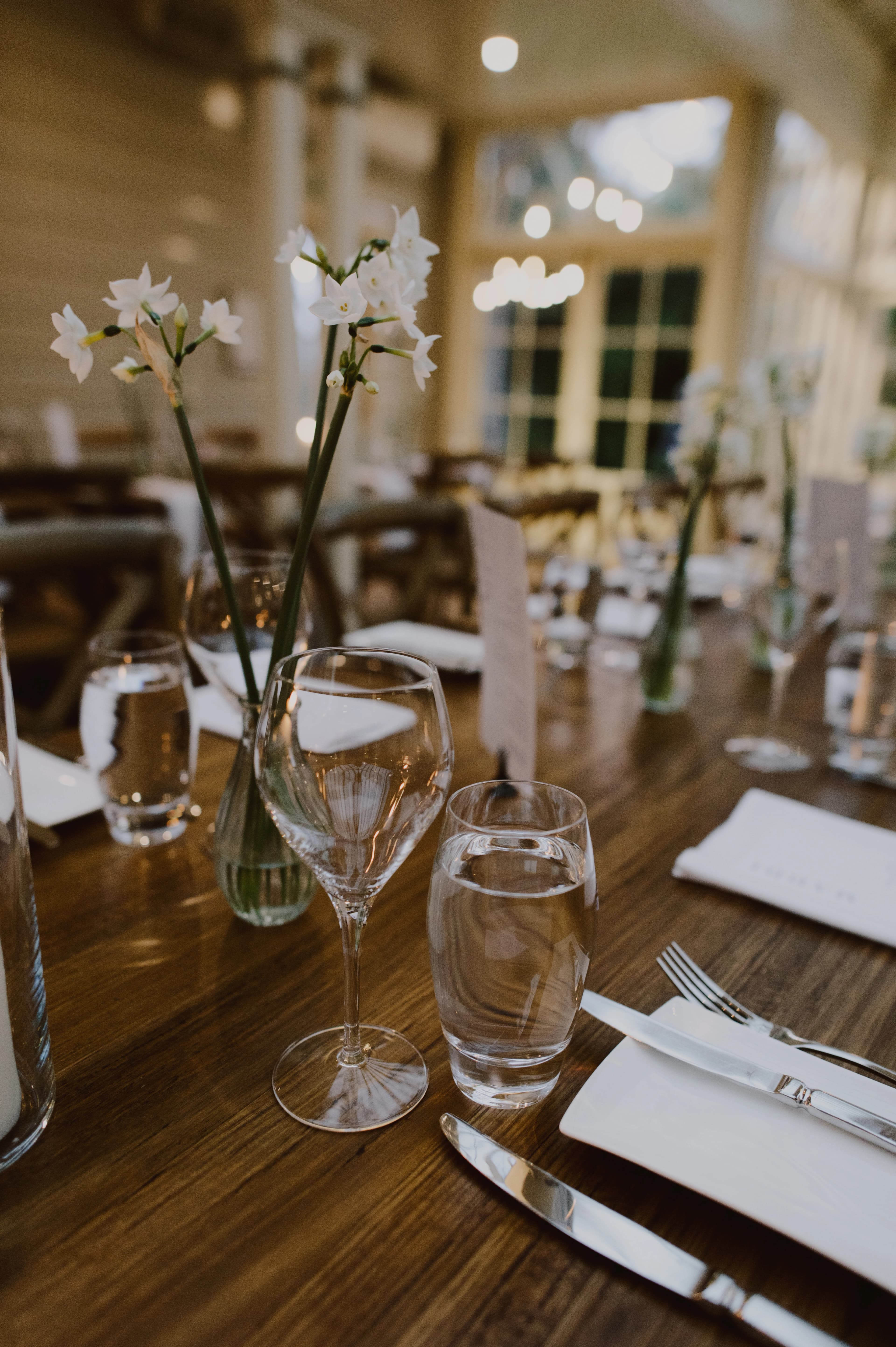 Reception glassware with daffodil flowers in the backdrop