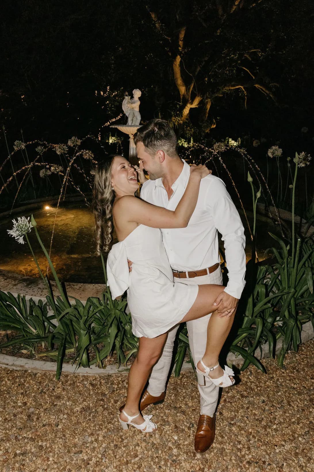 Bride and groom standing in front of fountain