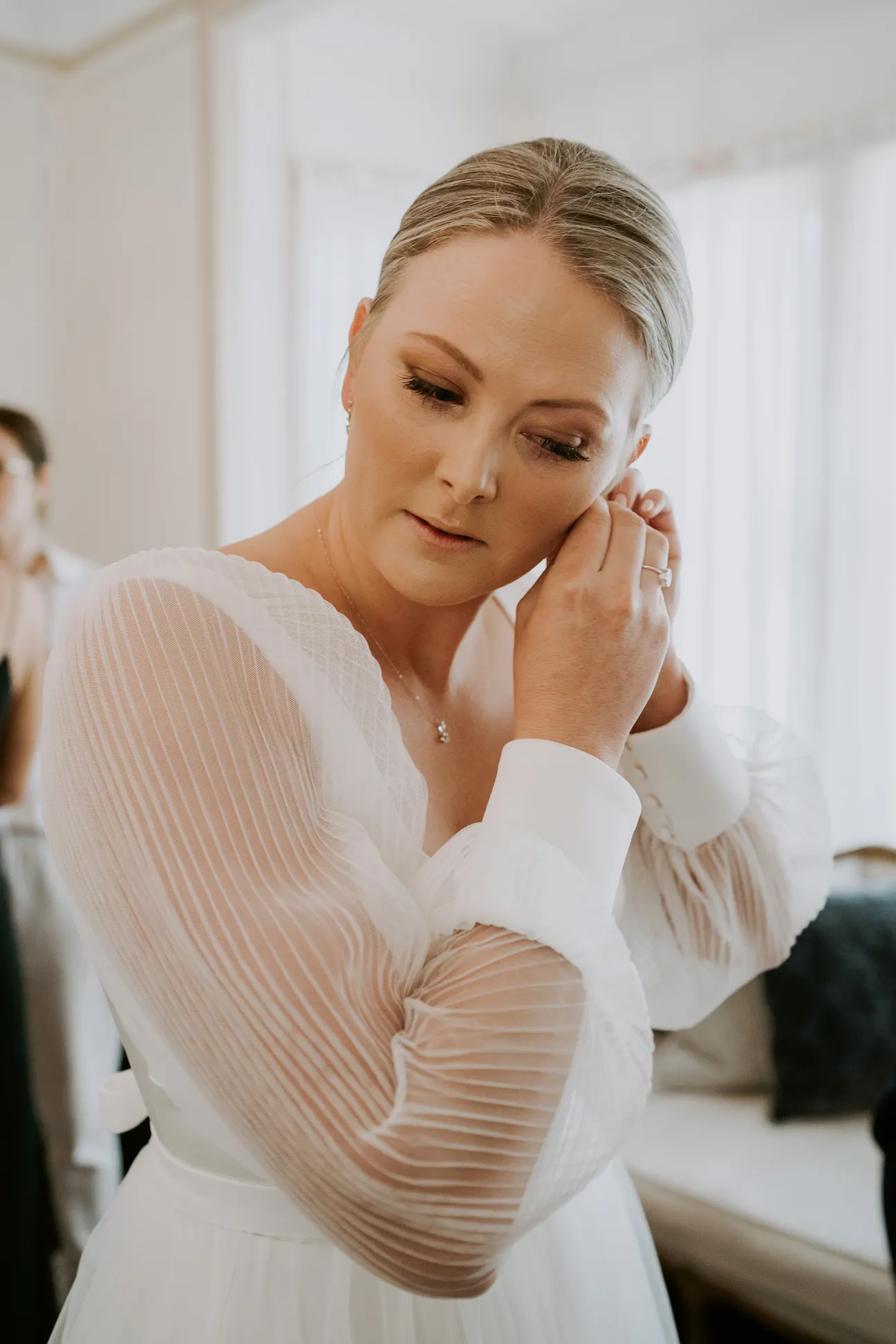 Bride putting in earrings