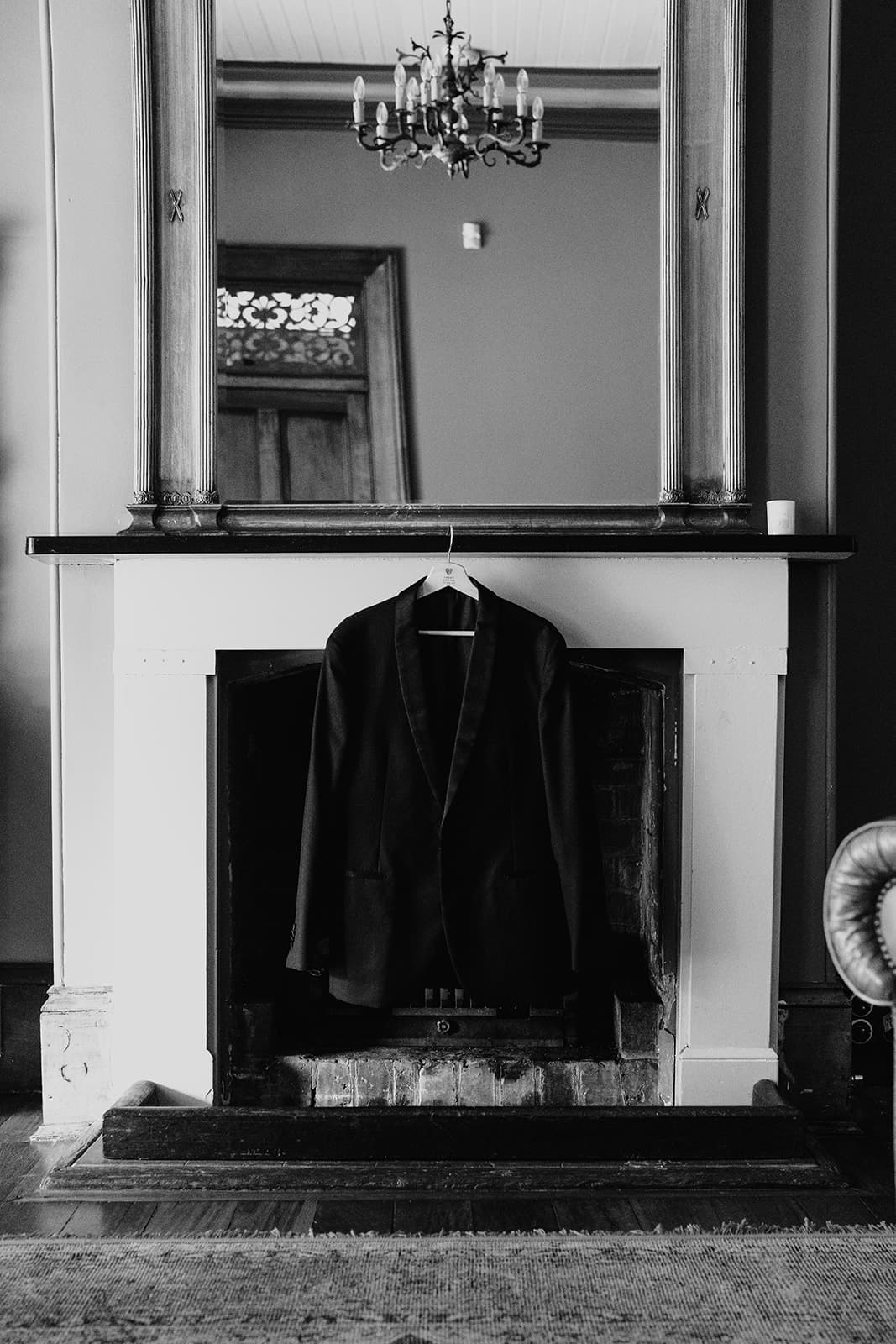 Groom suit jacket hanging on mantlepiece