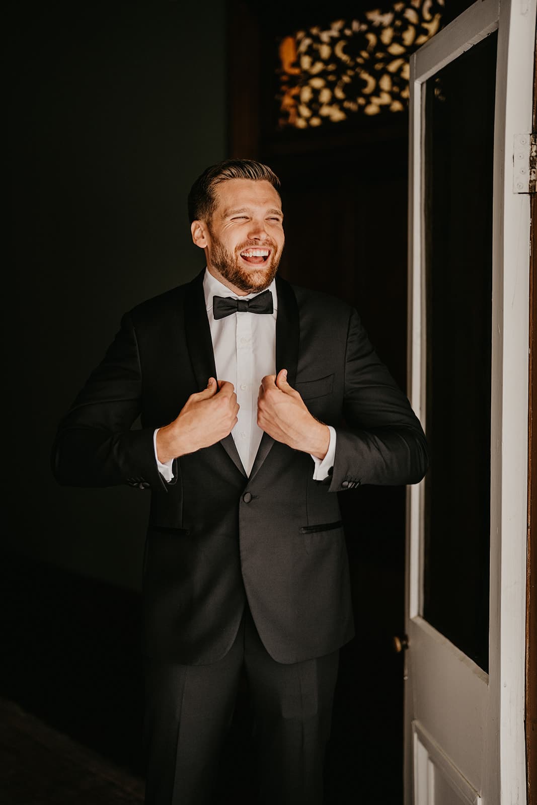 Groom putting on suit jacket
