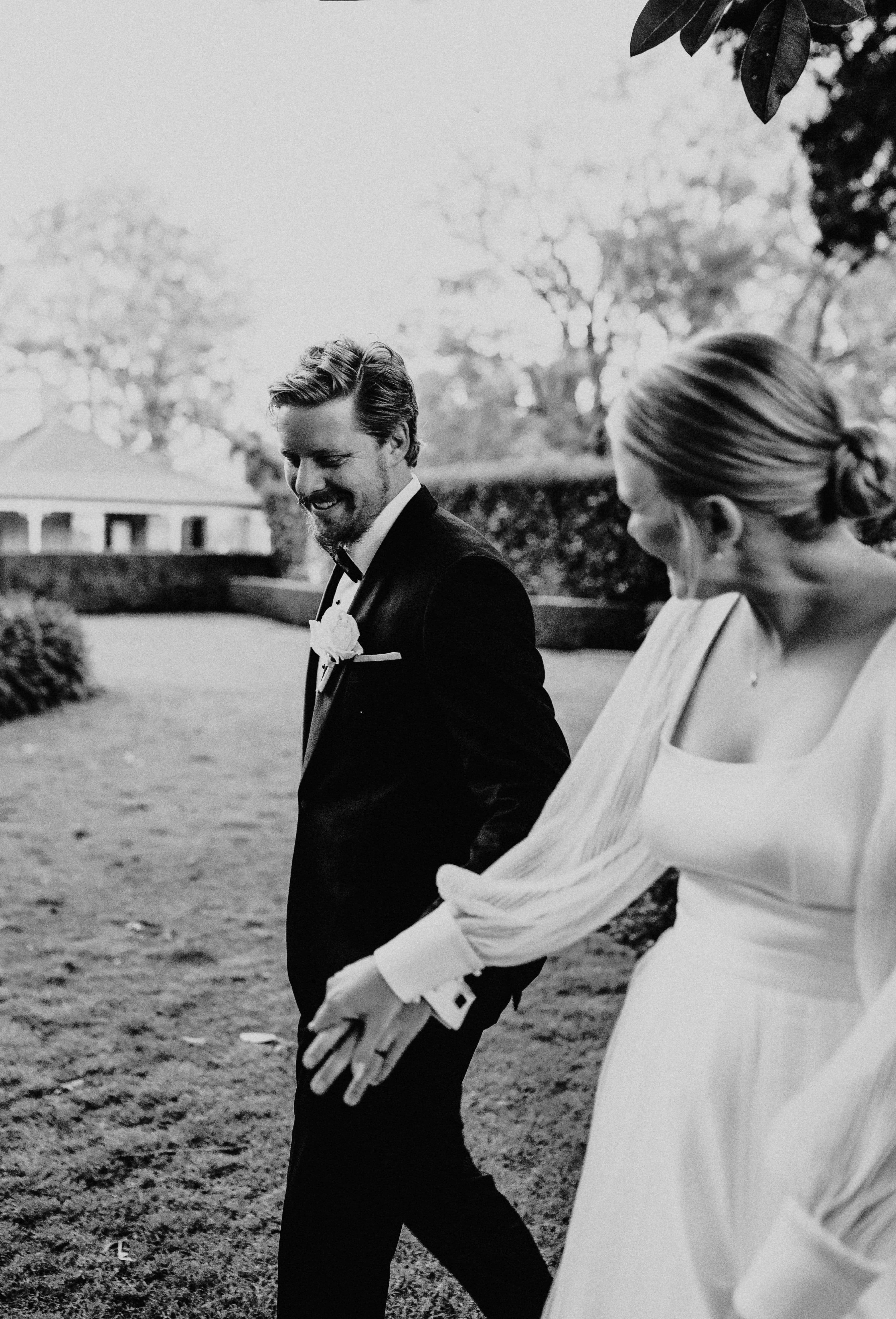 Bride and groom walking through gardens