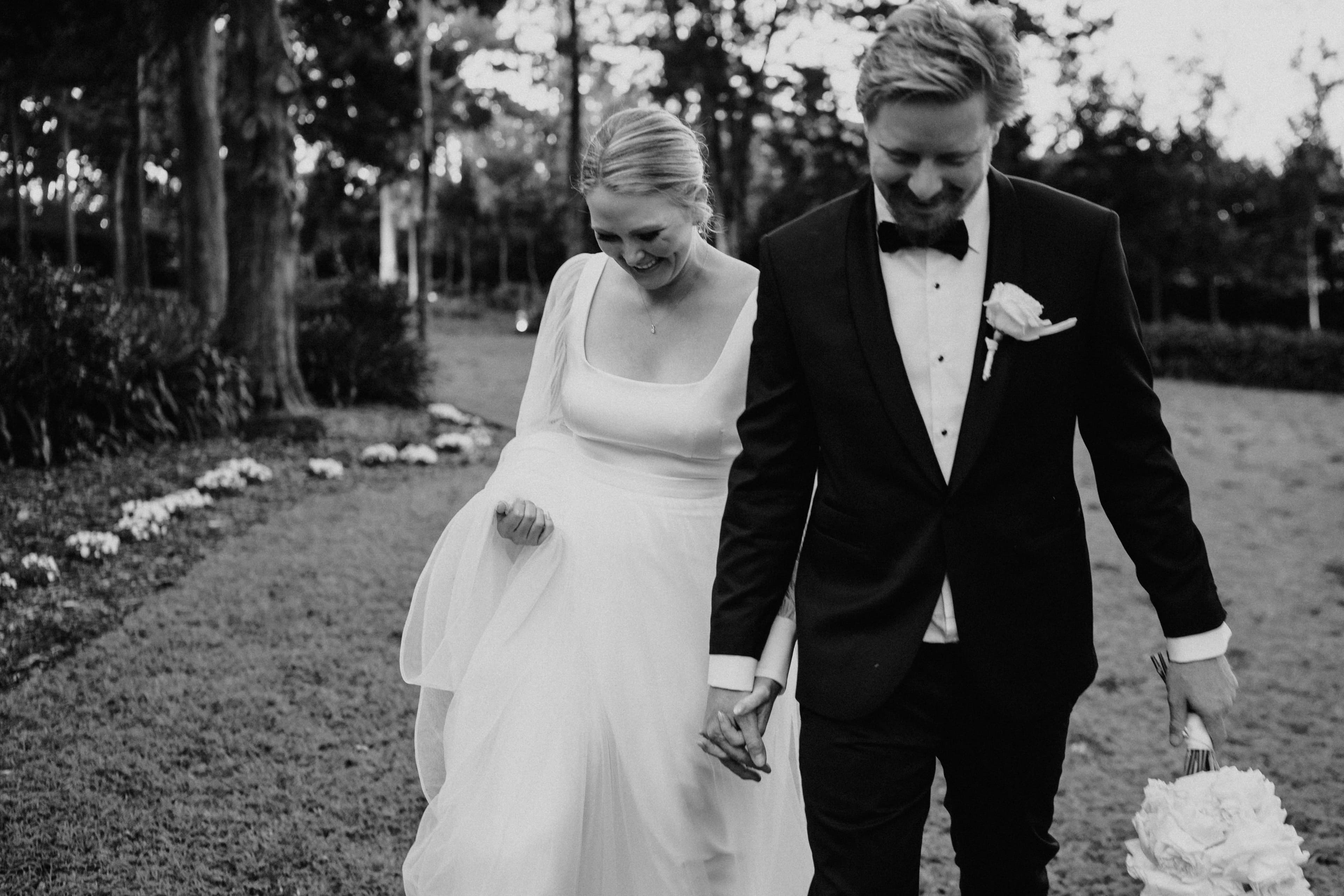 Bride and groom walking through gardens