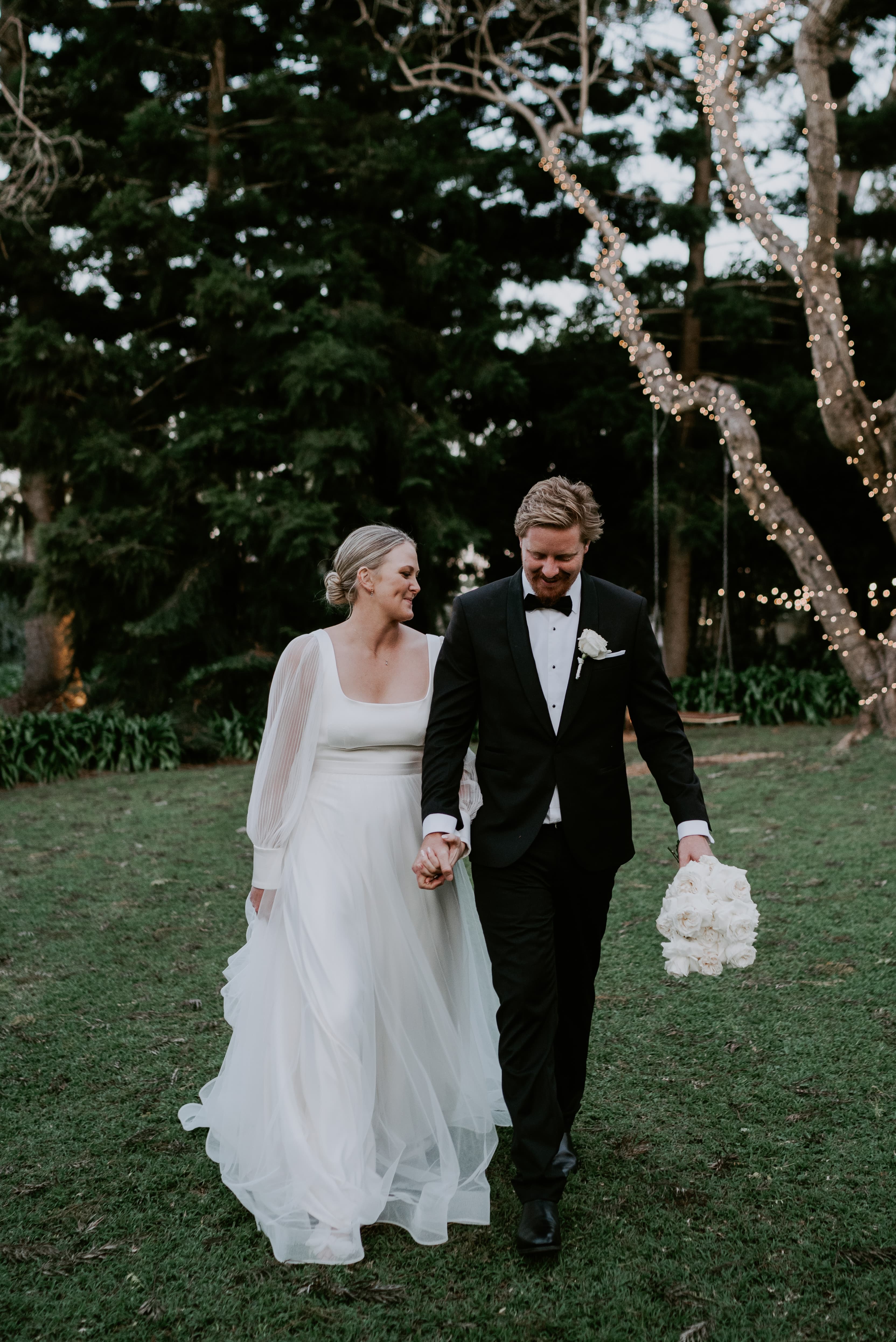 Bride and groom walking thriugh gardens