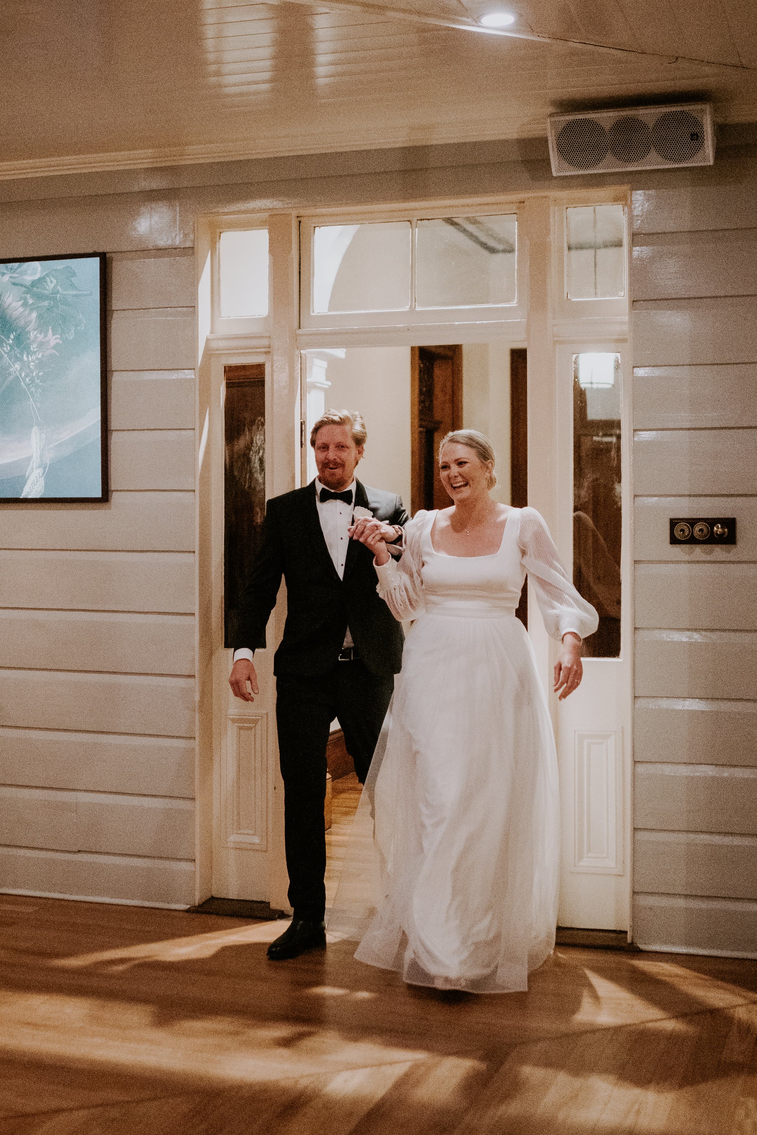 Bride and groom walking through wedding reception doorway