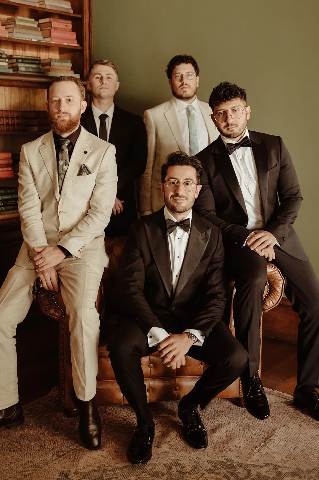 Groom and groomsmen sitting on leather couch