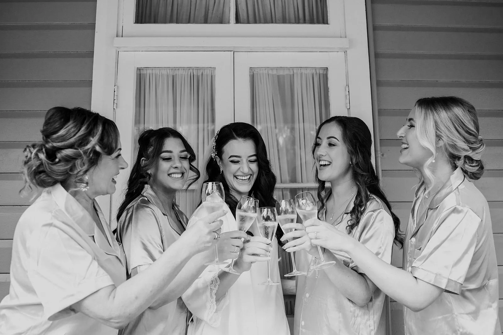 Bride and bridesmaids sipping champagne