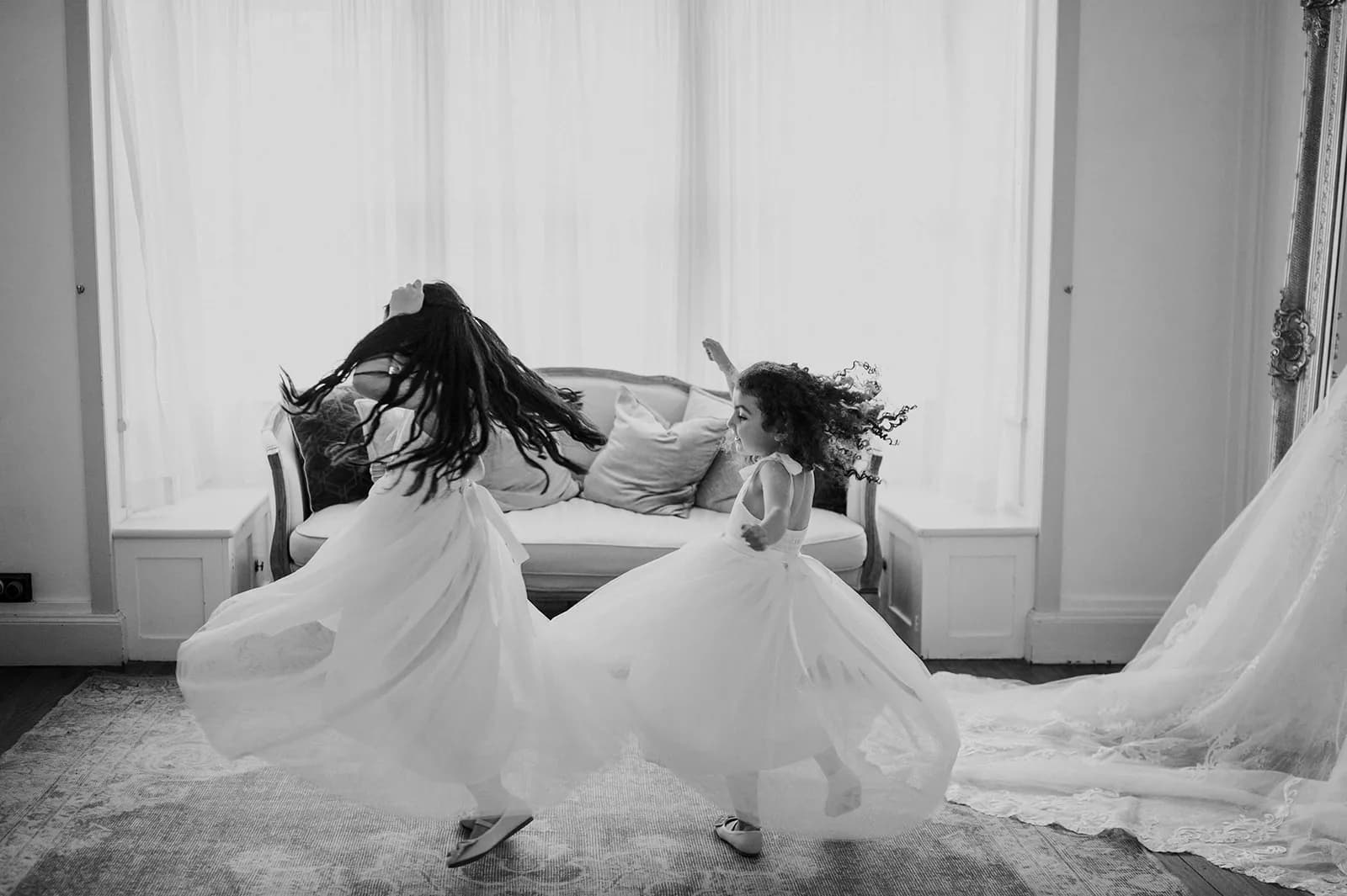 Flower girls twirling around in dresses