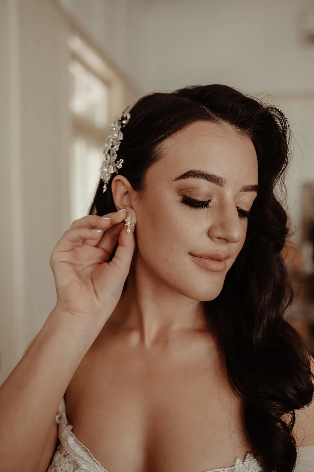 Bride putting in earrings