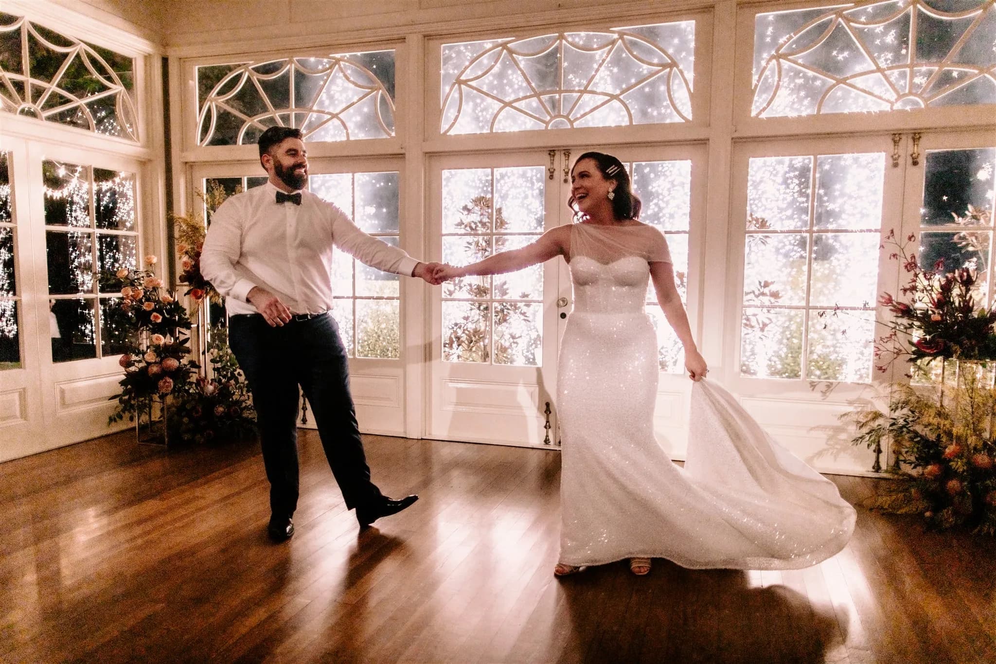 Bride and groom dancing at their wedding with with fireworks in the background