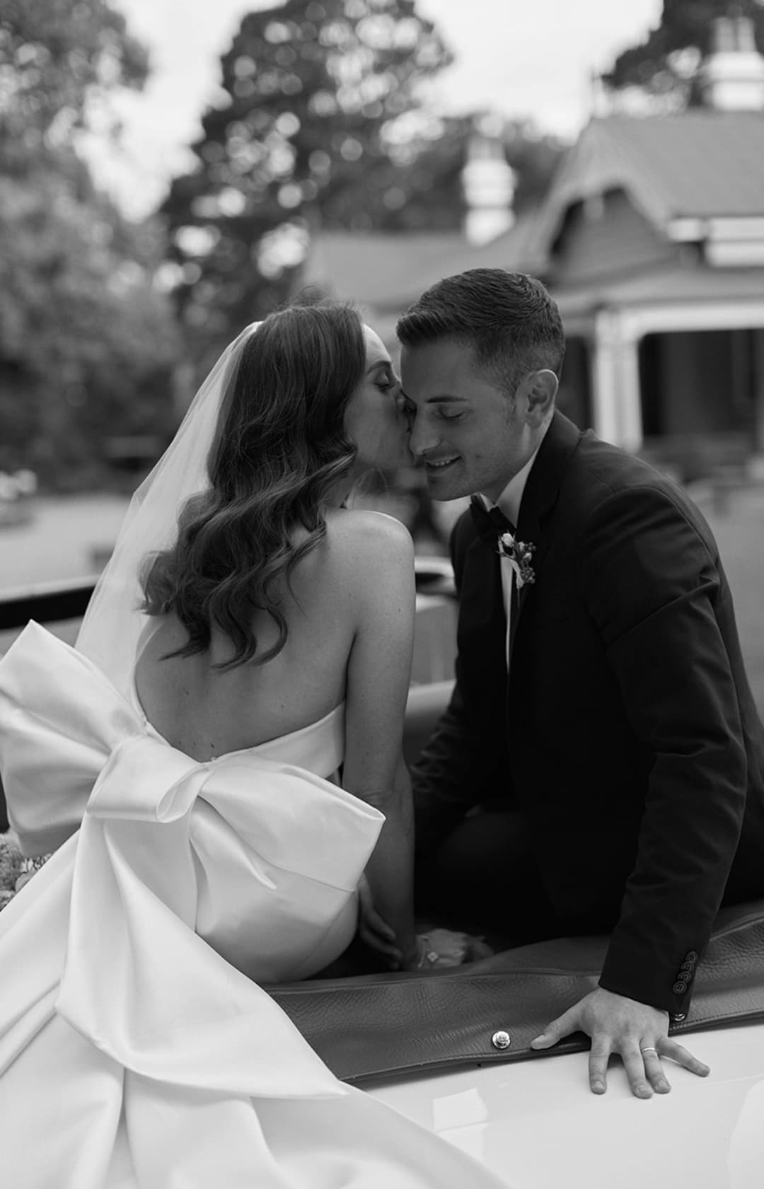 Couple kiss on back of car