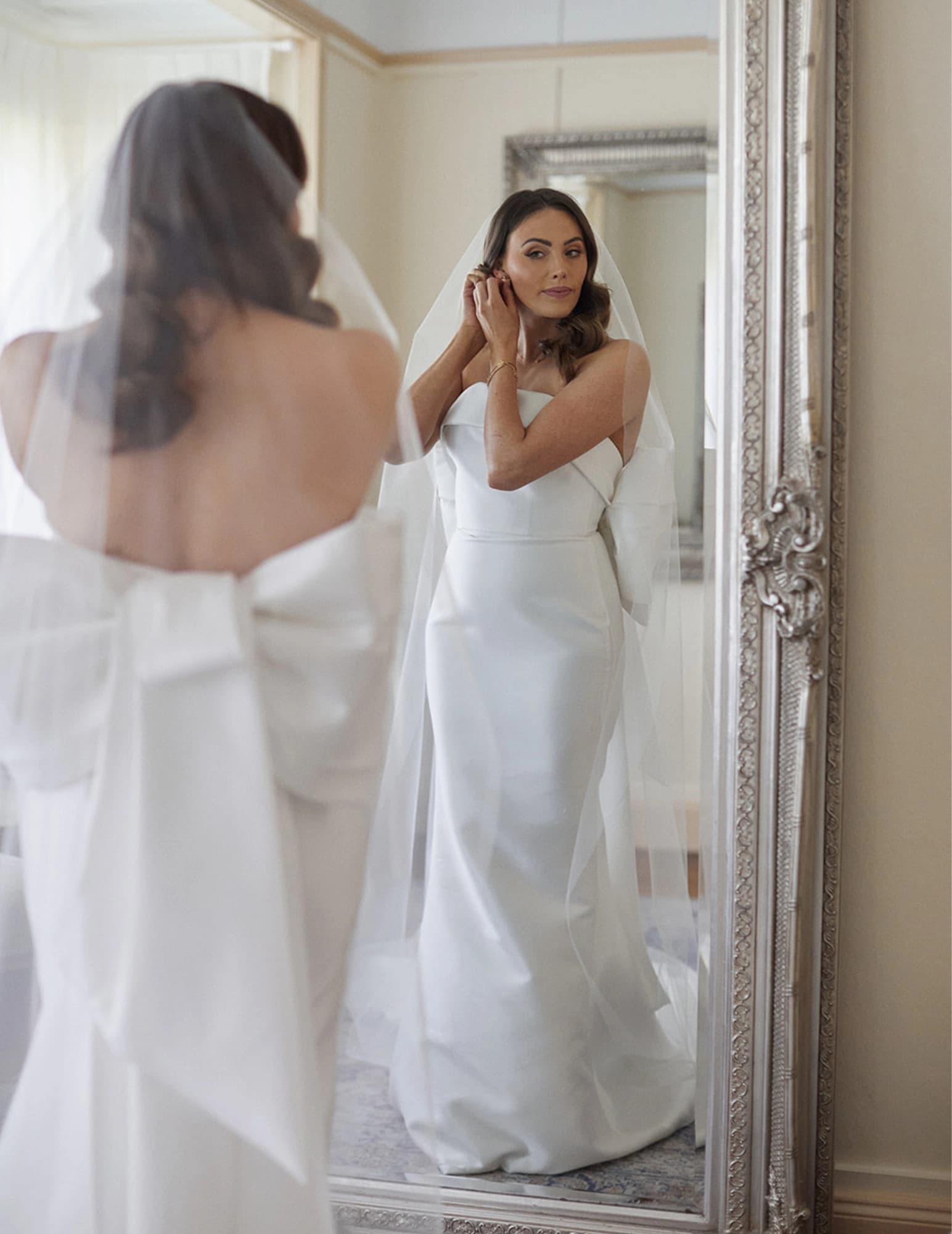 Bride adjusts earring in the bride's retreat