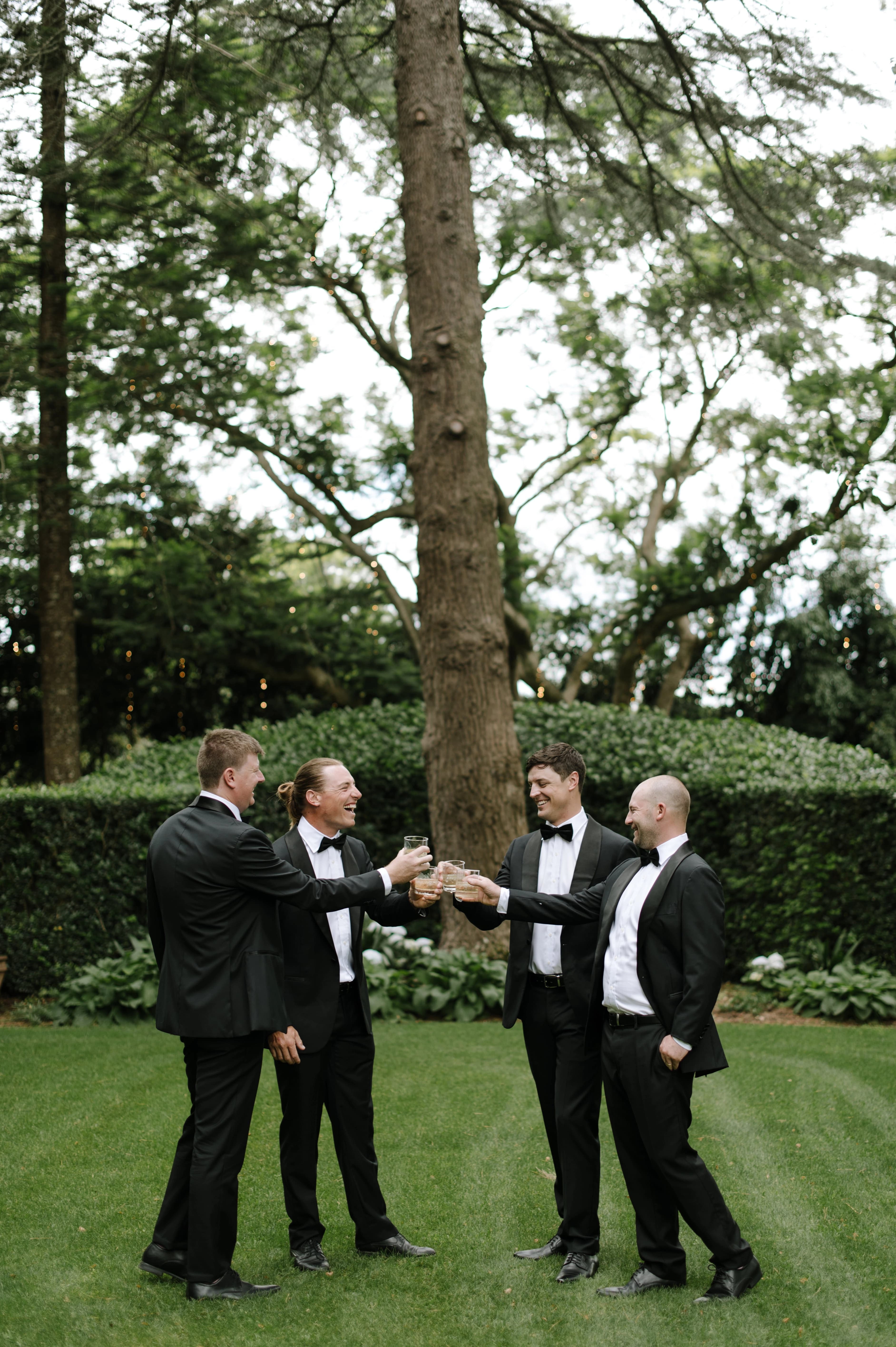 groomsmen raising glasses in a toast during a wedding celebration, smiling and enjoying the moment together.
