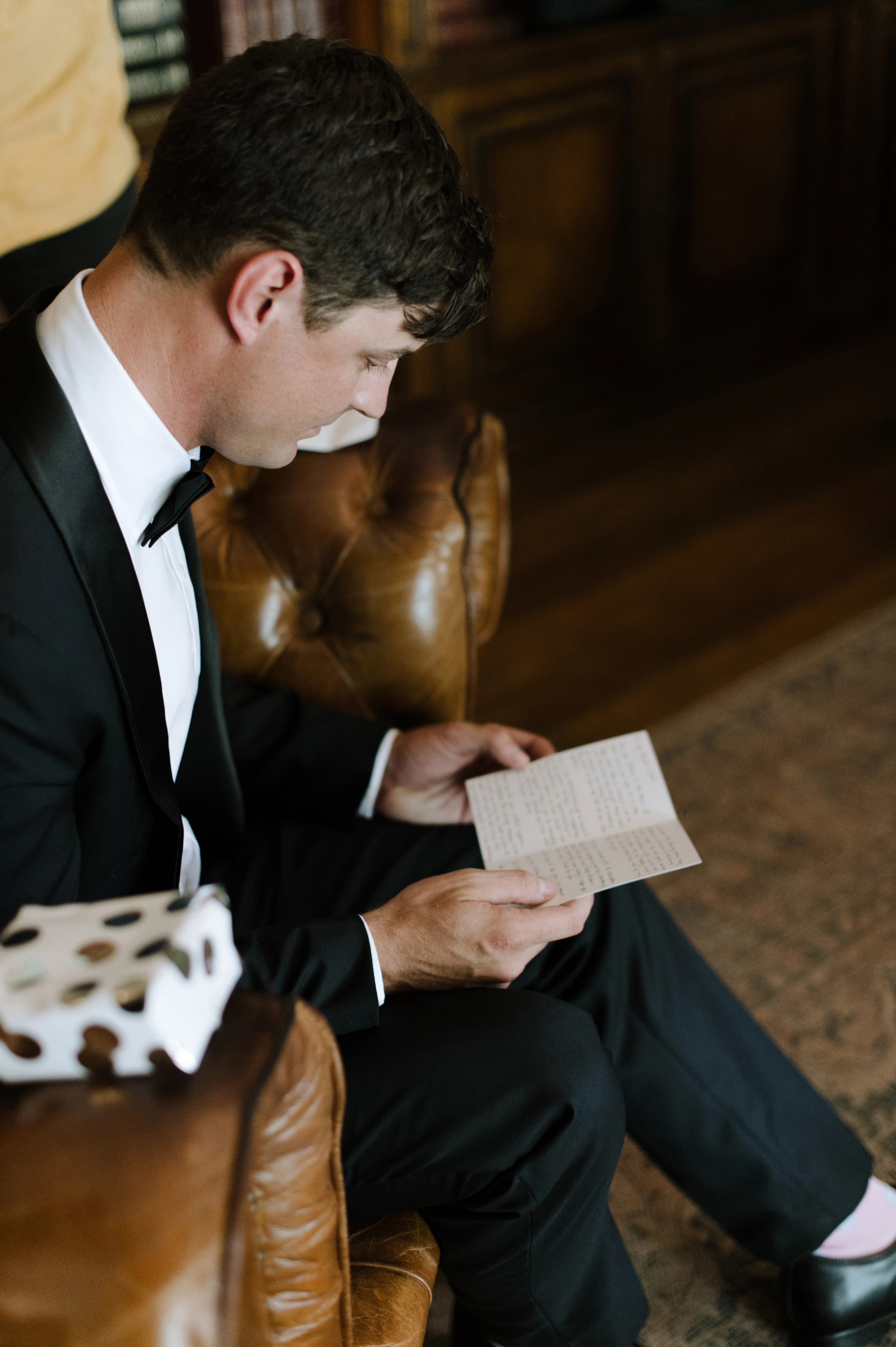 Groom reading a heartfelt letter before the wedding ceremony