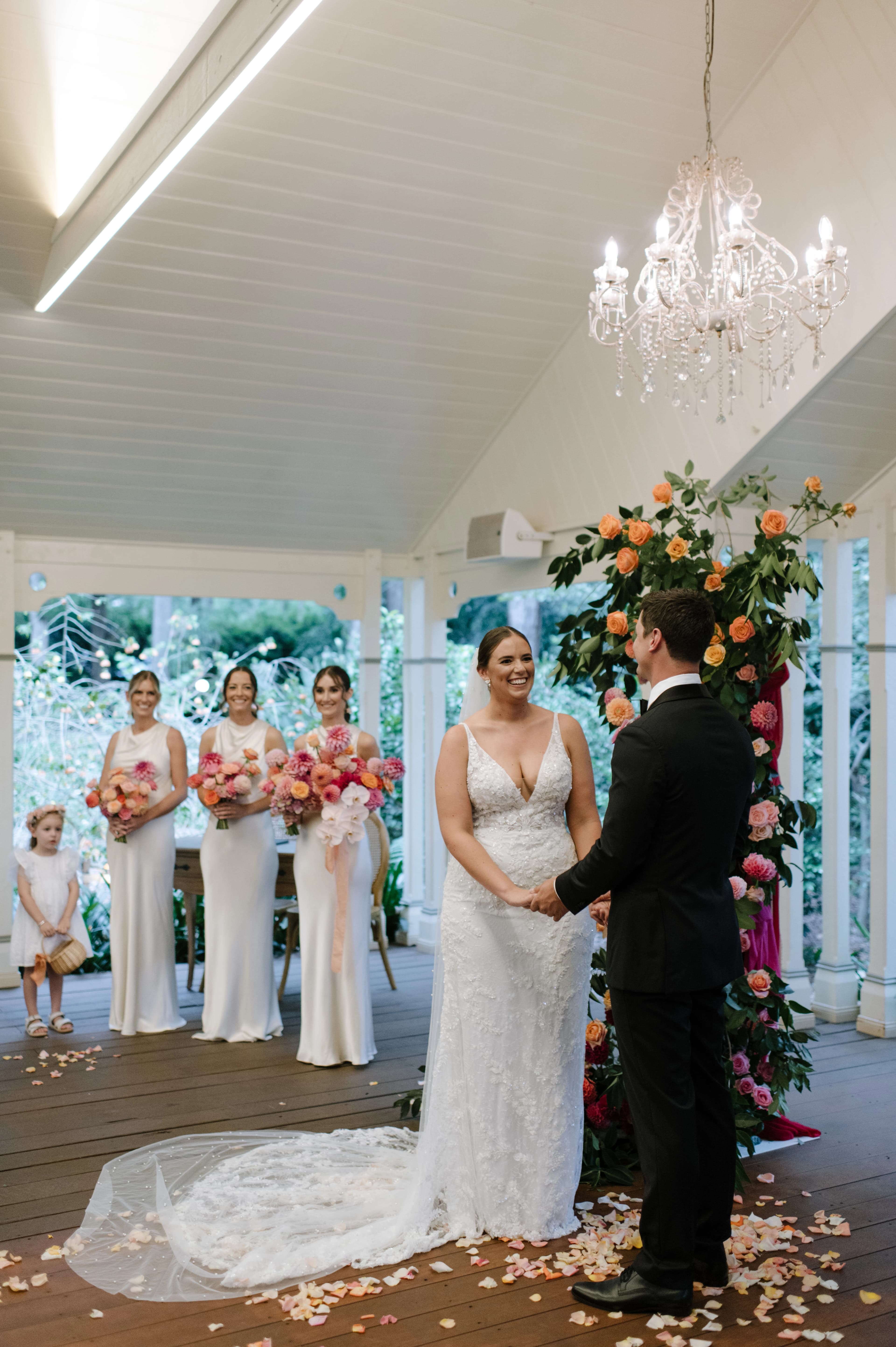 A couple exchanging vows, surrounded by floral arrangements and guests, creating a charming wedding atmosphere.
