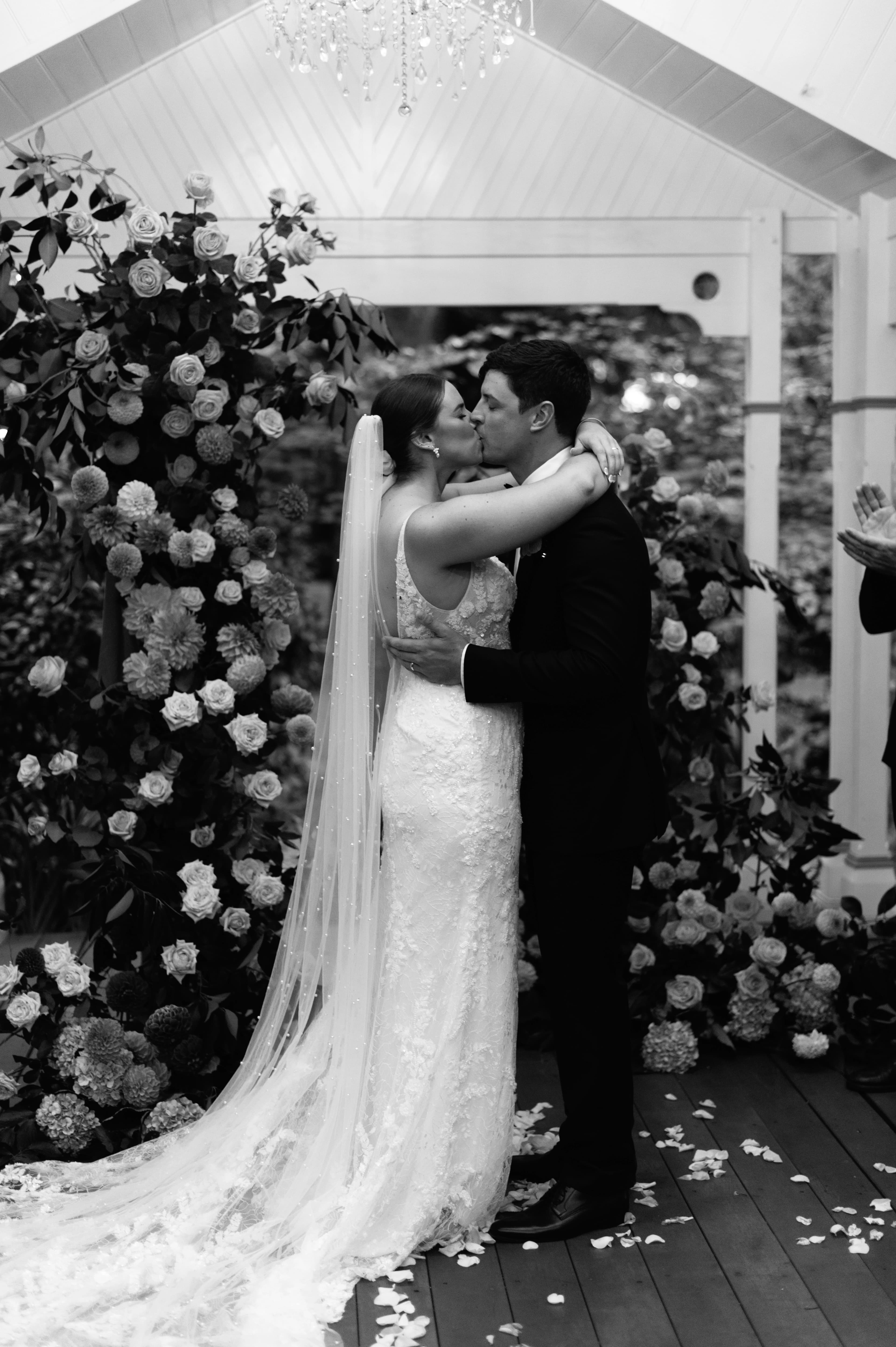 Elegant black and white wedding photo featuring the couple sharing a kiss
