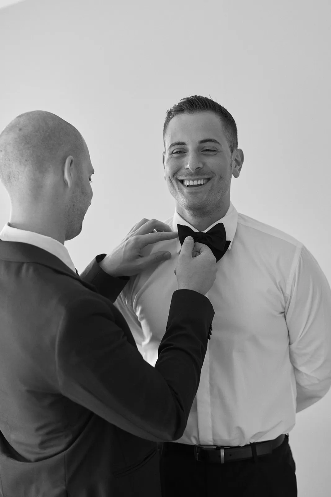 Groomsmen helping groom get dressed