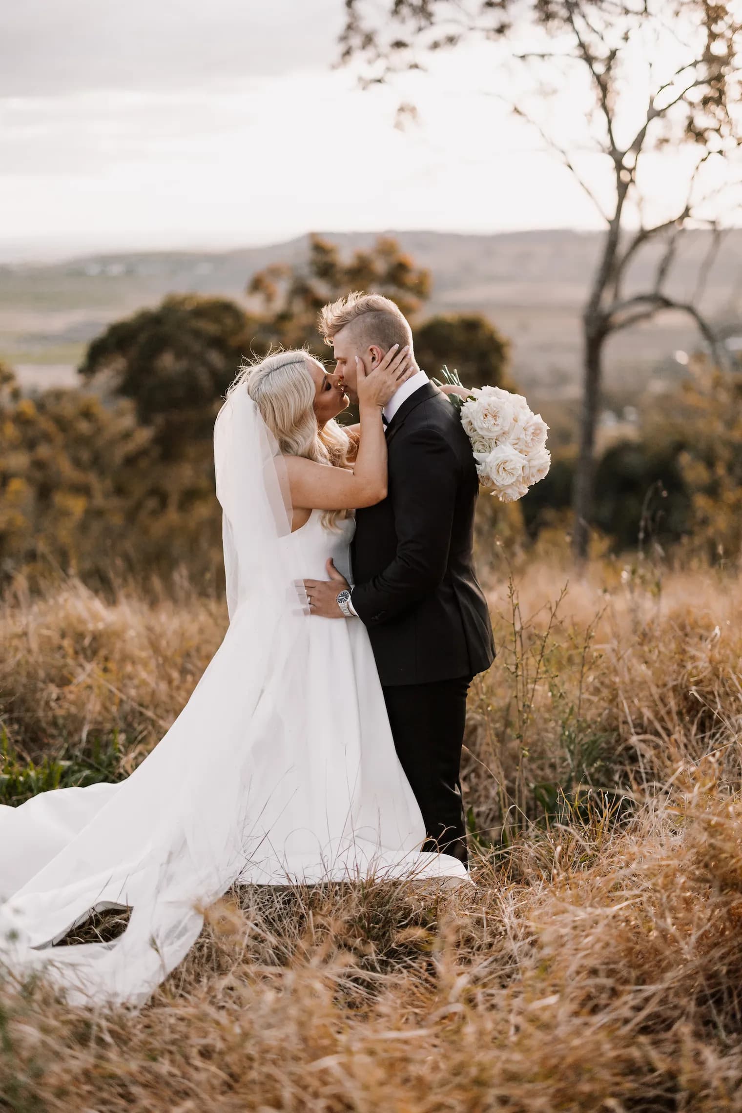 newlyweds enjoying a romantic kiss on their wedding day in the beautiful countryside which surrounds gabbinbar